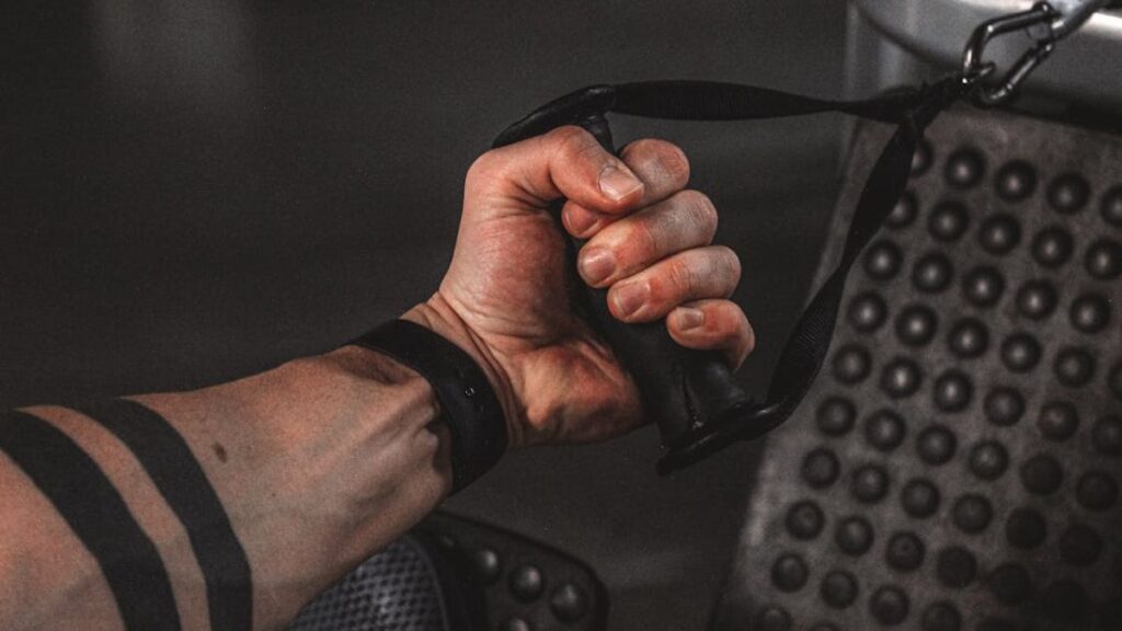 A man doing single-arm cable rows pull exercises.