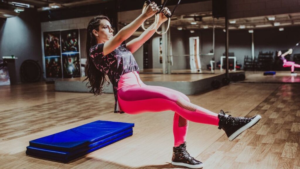 women performing a TRX row pull exercise.