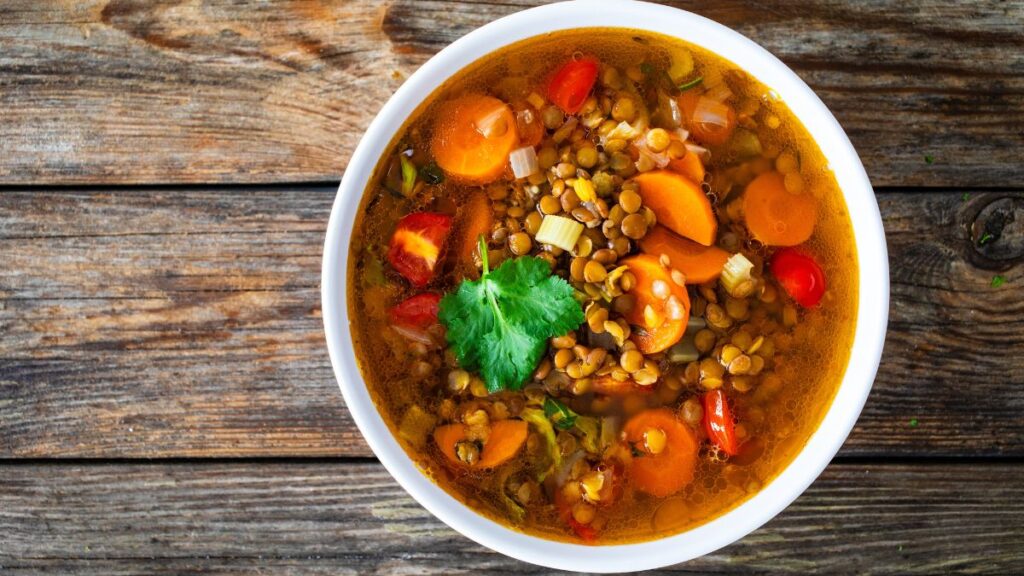 Fresh vegetable soup with lentil on wooden table